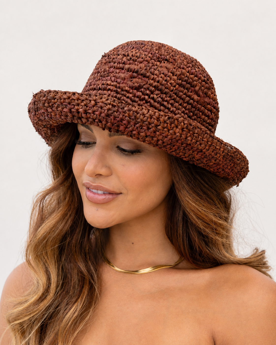 Woman wearing a brown woven hat on a white background