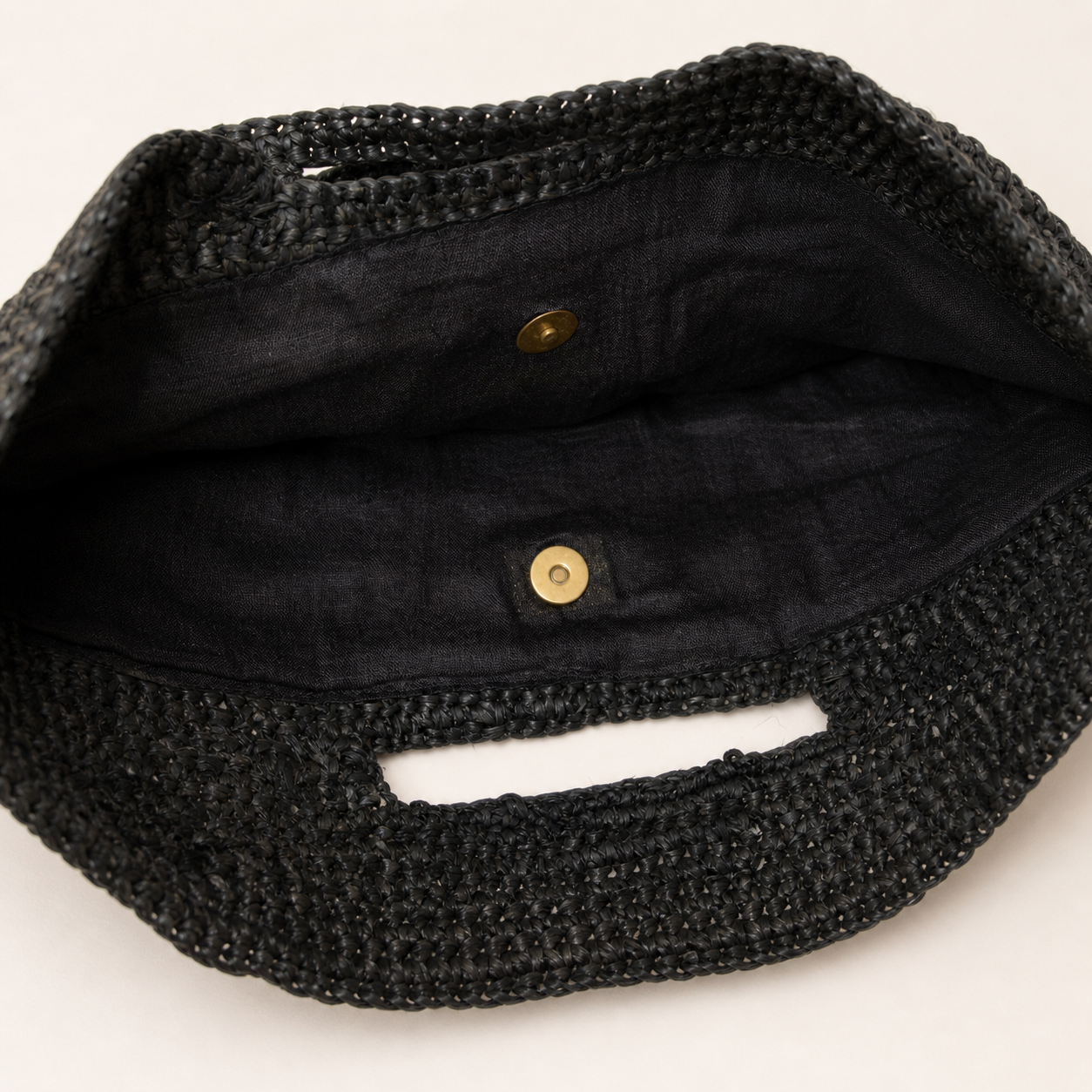Close-up of a black woven bag with a textured surface on a white background