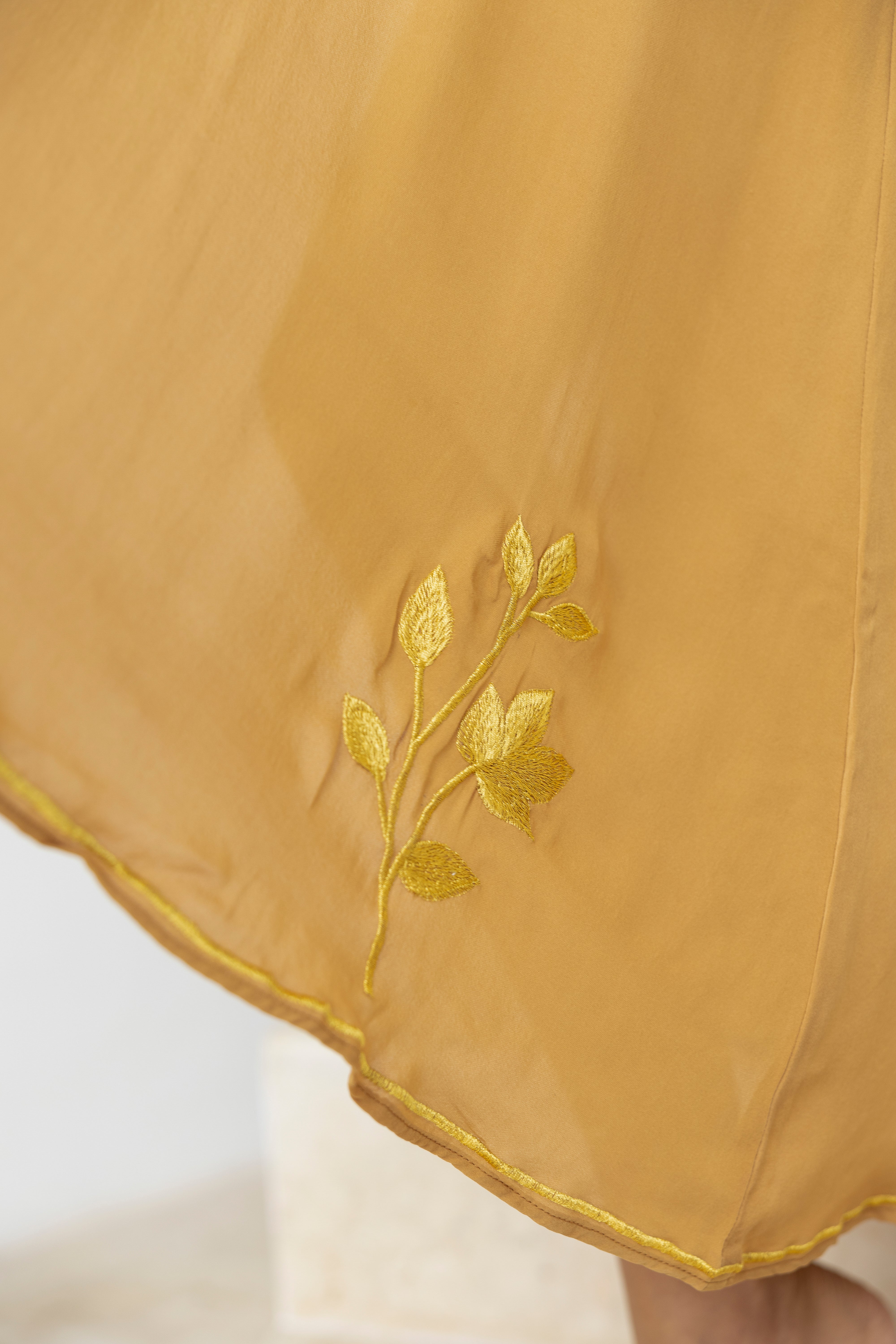 Taupe duster with gold embroidery on a white background